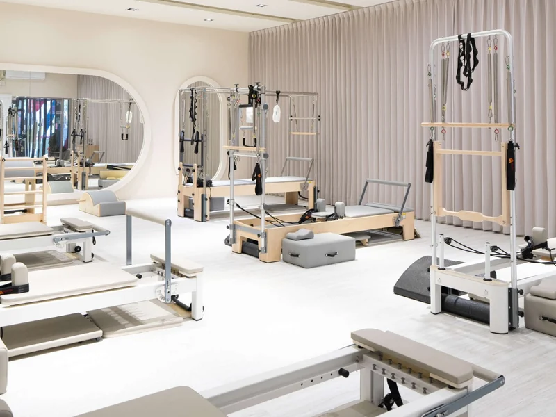 A Pilates studio with reformers arranged for a class